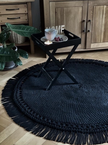 Czarny dywan z frędzlami w slonie