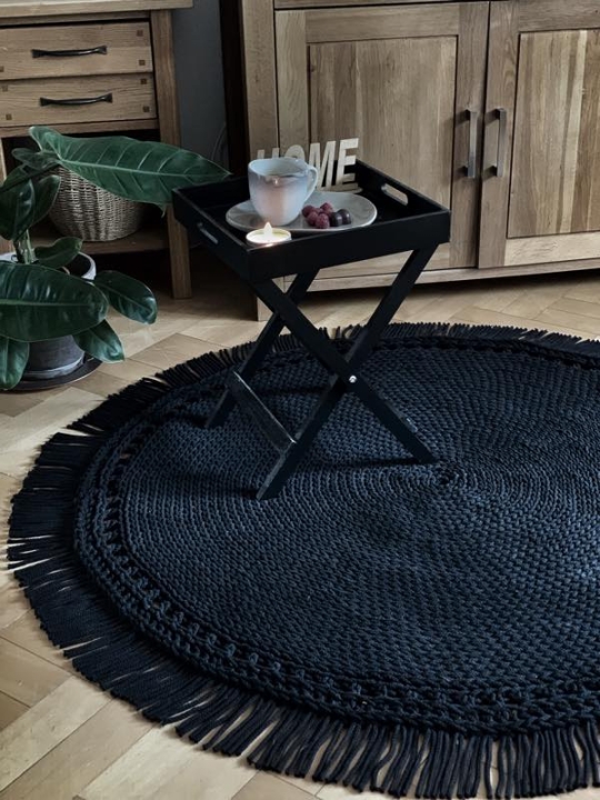 Czarny dywan z frędzlami w slonie